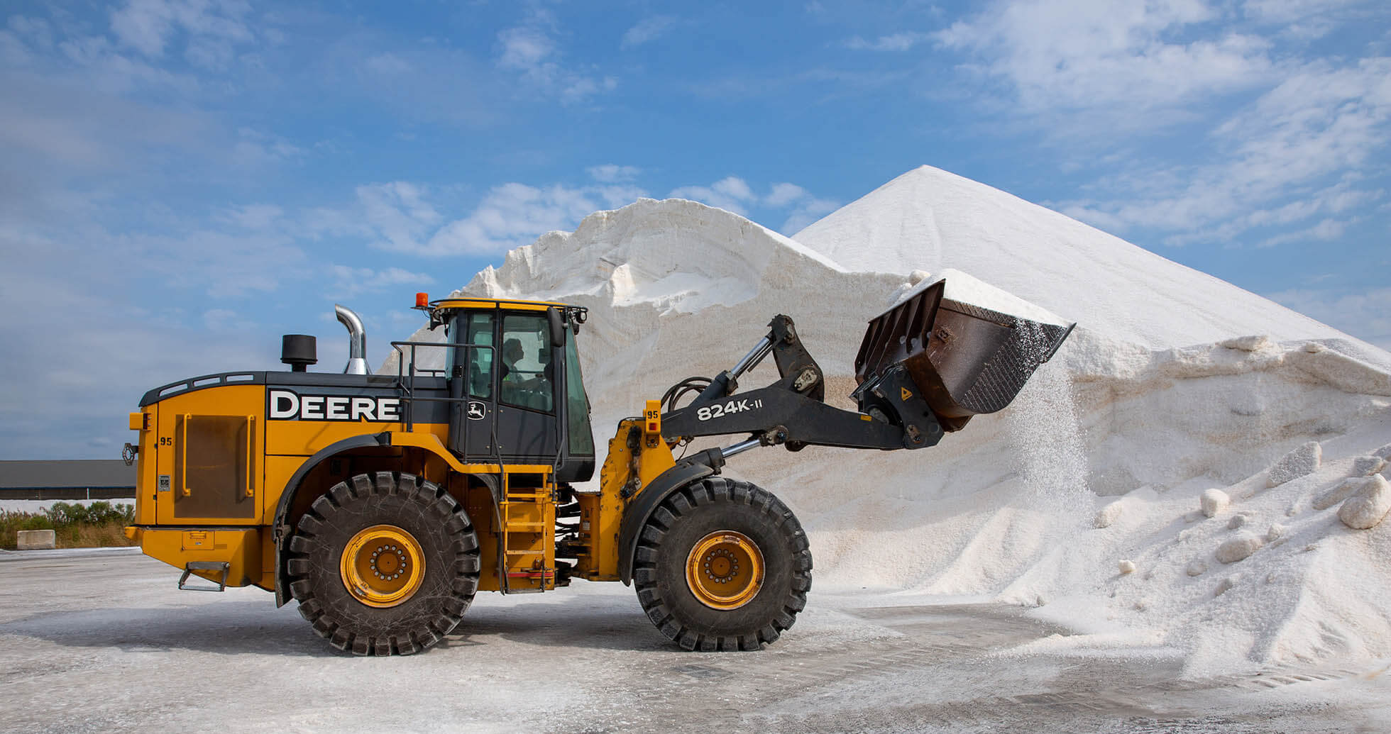 john deere tractor moving pile of road salt at rukert terminals storage facility
